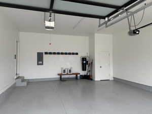 Garage featuring electric panel and a garage door opener