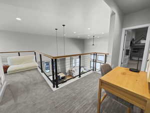 Hallway with carpet flooring, recessed lighting, and an upstairs landing