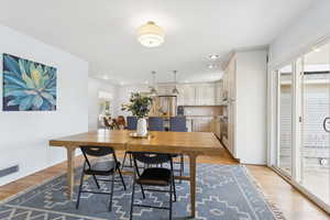 Dining area with light wood-style flooring and recessed lighting
