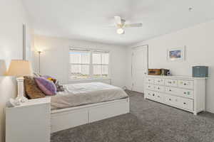 Carpeted bedroom featuring a ceiling fan