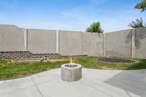 View of patio / terrace featuring a trampoline and an outdoor fire pit