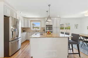 Kitchen with stainless steel appliances, healthy amount of natural light, tasteful backsplash, light wood-style floors, and recessed lighting