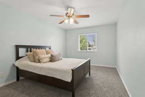 Carpeted bedroom featuring baseboards and ceiling fan