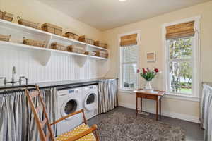 Laundry room featuring separate washer and dryer and dark tile patterned flooring