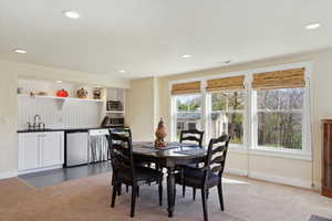 Carpeted dining space with baseboards and recessed lighting