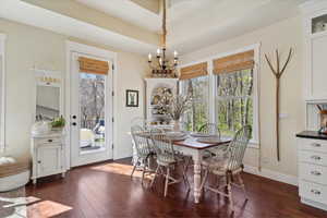 Dining area featuring a chandelier, healthy amount of natural light, and dark wood-style floors