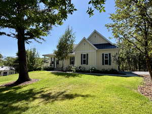 View of front of home featuring board and batten siding, a front lawn, and a standing seam roof