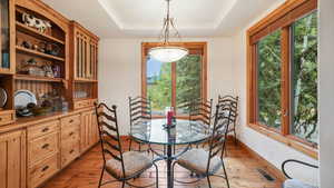 Dining room featuring light wood-style floors and a tray ceiling