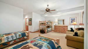 Carpeted bedroom with a ceiling fan, recessed lighting, and a textured ceiling
