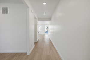 Hall featuring light wood-style flooring and recessed lighting