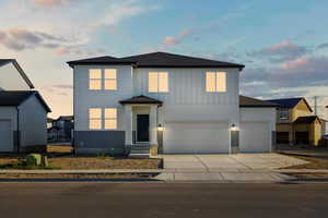 View of front of home with roof with shingles, driveway, a garage, and board and batten siding