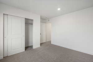 Unfurnished bedroom featuring carpet flooring, a closet, and recessed lighting