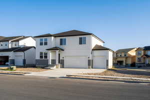 View of front of home with driveway, a shingled roof, a residential view, and an attached garage
