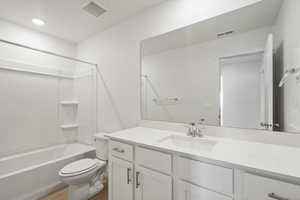 Bathroom featuring vanity, tub / shower combination, light wood-type flooring, and recessed lighting