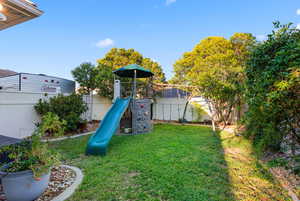 Fenced backyard with a playground