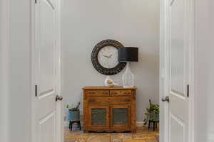Corridor with stone tile flooring and baseboards