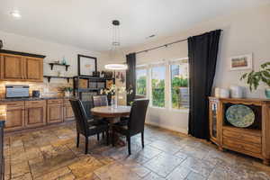 Dining area featuring baseboards and stone tile floors