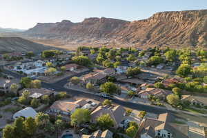 Aerial view of property and surrounding area featuring a mountain backdrop and nearby suburban area