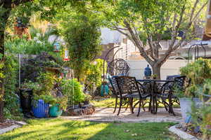 View of yard with outdoor dining space and a patio