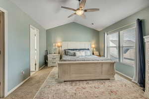 Bedroom featuring vaulted ceiling, light carpet, and ceiling fan