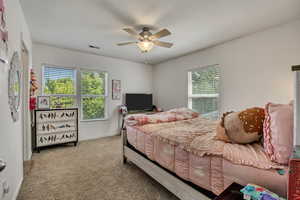 Carpeted bedroom featuring ceiling fan and baseboards