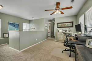 Carpeted office space with baseboards and ceiling fan