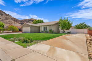Ranch-style house with driveway, an attached garage, stucco siding, a tiled roof, and a mountain view