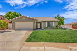 Ranch-style home with a garage, driveway, a tile roof, and stucco siding