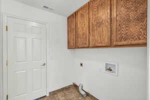 Laundry area featuring hookup for a washing machine, cabinet space, electric dryer hookup, and gas dryer hookup