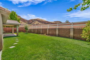 Fenced backyard featuring a patio and a mountain view