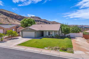 Ranch-style home with driveway, a garage, a mountain view, stucco siding, and a tile roof
