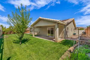 Back of house featuring a fenced backyard, stucco siding, a tiled roof, and roof mounted solar panels