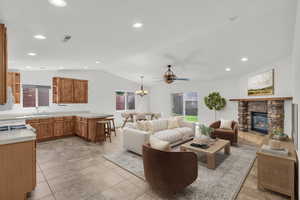 Living room with recessed lighting, a fireplace, a chandelier, lofted ceiling, and light tile patterned flooring