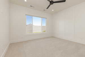 Unfurnished room with light carpet, a ceiling fan, recessed lighting, and a decorative wall