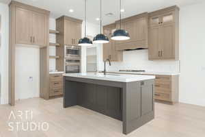Kitchen with backsplash, light countertops, a center island with sink, light wood finished floors, and recessed lighting