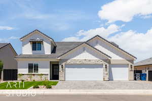 View of front of house with decorative driveway and stone siding