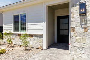 Entrance to property featuring stone siding