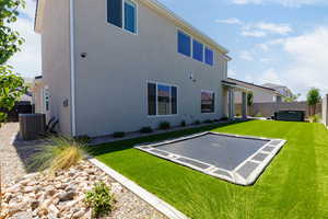 Rear view of house featuring a fenced backyard, a patio area, stucco siding, and a hot tub