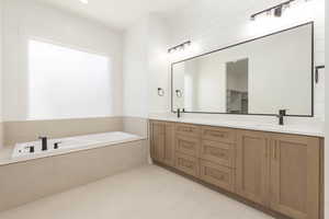 Full bathroom featuring double vanity, a garden tub, and recessed lighting