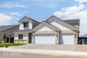 View of front of property featuring decorative driveway and stone siding