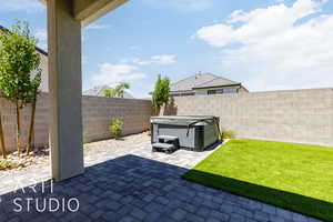 Fenced backyard with a patio and a hot tub