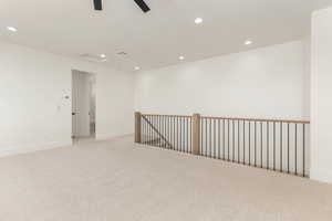 Spare room featuring light colored carpet, recessed lighting, and ceiling fan