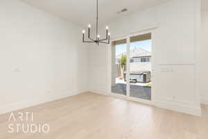 Unfurnished dining area featuring a chandelier and light wood finished floors