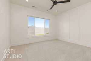 Spare room featuring a decorative wall, light colored carpet, ceiling fan, and recessed lighting