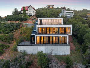 Back of house at dusk featuring a balcony
