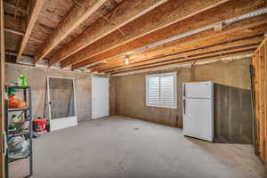 Basement with freestanding refrigerator