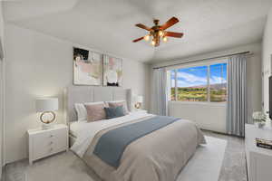 Bedroom with a textured ceiling, light colored carpet, and a ceiling fan