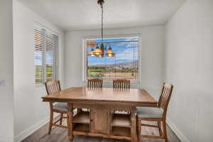Dining space featuring a chandelier, wood finished floors, plenty of natural light, and a textured ceiling