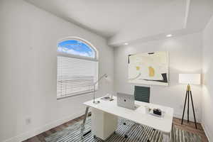 Office space featuring wood finished floors, lofted ceiling, and recessed lighting