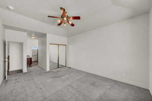 Unfurnished bedroom featuring carpet, a closet, a textured ceiling, and a ceiling fan
